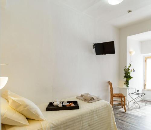 a white bedroom with a bed with a tray on it at Hotel San Francesco e il lupo in Gubbio