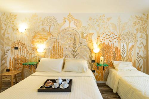 a hotel room with two beds with a tray of food at Hotel San Francesco e il lupo in Gubbio