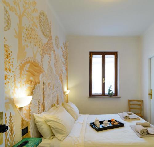 a bedroom with a bed with a tray of food on it at Hotel San Francesco e il lupo in Gubbio