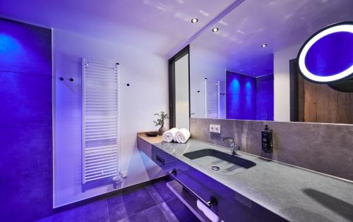 a bathroom with a sink and a large mirror at Landhotel Sternwirt - Das Wellnesshotel zwischen Nürnberg und Amberg in Högen