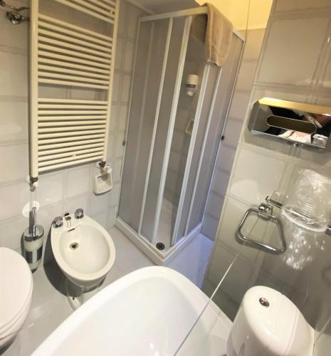 a bathroom with a shower and a toilet and a sink at Hotel San Francesco e il lupo in Gubbio