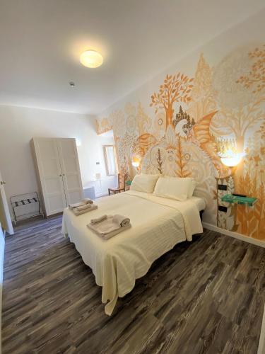 a bedroom with a large bed with a floral wallpaper at Hotel San Francesco e il lupo in Gubbio