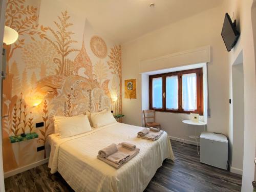 a bedroom with a large bed with towels on it at Hotel San Francesco e il lupo in Gubbio