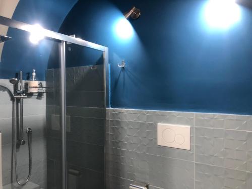 a bathroom with a shower and a blue wall at La Casa di Orlando in Catania