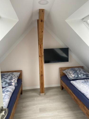 2 camas en una habitación con TV en la pared en Maisonette-Wohnung An der Weißen Mauer 14, en Görlitz
