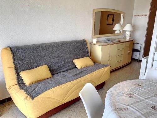 um quarto com um sofá com um espelho e uma cama em Studio Balaruc-les-Bains, 1 pièce, 4 personnes - FR-1-503-82 em Balaruc-les-Bains