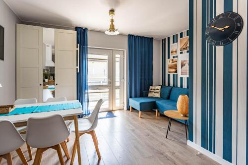 - un salon avec un canapé bleu et une table dans l'établissement Apartamenty Marynarskie, à Rowy