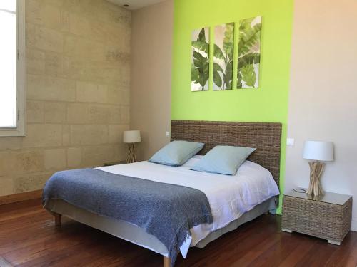1 dormitorio con cama y pared verde en B&B La Halte Montaigne, en Burdeos