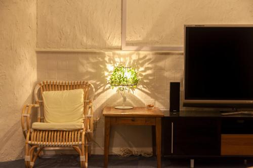a room with a table and a chair and a tv at VERY in Naha