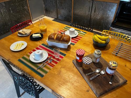 una mesa de madera con comida encima en La Grange de Grandviala en La Chaze-de-Peyre