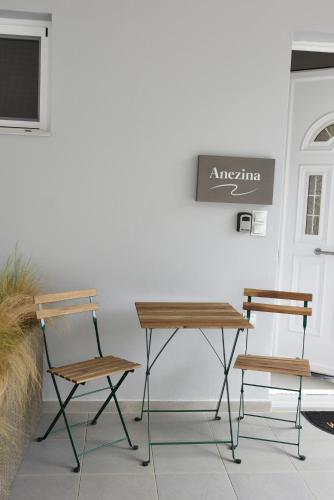 a table and two chairs in front of a door at Studio Dionysia-Anezina in Tolo