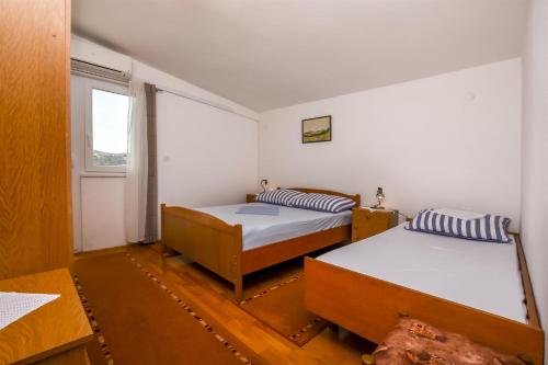 um quarto com 2 camas e uma janela em Apartment Kucinic em Rogoznica