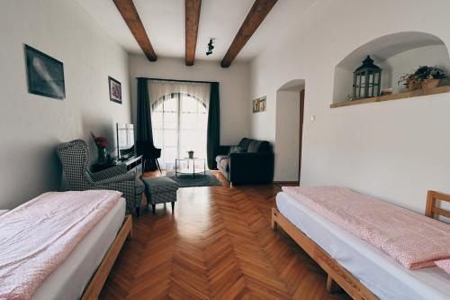a bedroom with two beds and a living room at Kutná Hora Apartment in Kutná Hora