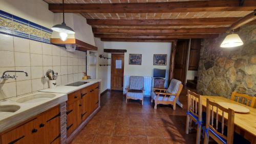a kitchen with a sink and a table and chairs at El Jardí de la Vileta - Cornudella de Montsant in Cornudella