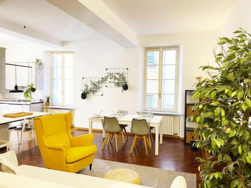 une cuisine et une salle à manger avec des chaises jaunes et une table dans l'établissement Wild Apartment, à Parme