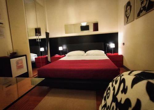 - une chambre avec un grand lit et une couverture rouge dans l'établissement Hotel L' Orto degli Otelli, à Frosinone