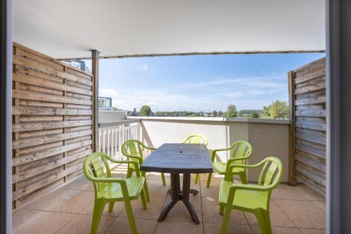un patio avec une table et des chaises sur un balcon dans l'établissement Le Cormoran, à Courseulles-sur-Mer