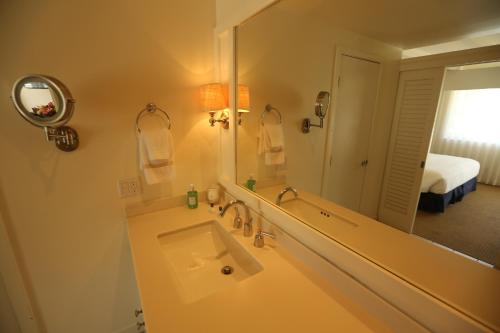 baño con lavabo y espejo grande en Pavilion Hotel, en Avalon