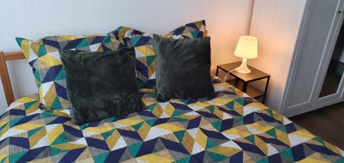 a bedroom with a bed with pillows and a lamp at COSY ROOM IN ANTWERPEN in Mortsel