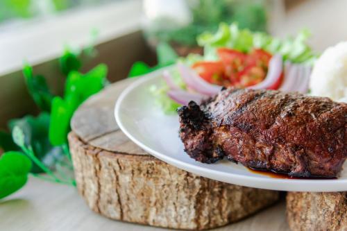 a plate of food with a piece of meat and salad at ibis Styles Curitiba Aeroporto in São José dos Pinhais