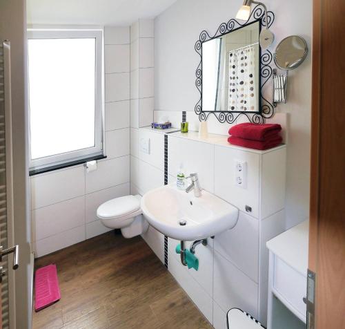 a white bathroom with a sink and a toilet at Exklusiv Ferienwohnung Bodensee in Uhldingen-Mühlhofen