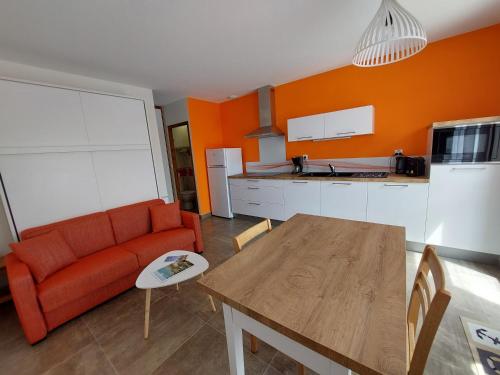 un salon avec un canapé rouge et une table dans l'établissement Les Marinières d'Oléron, à Boyardville