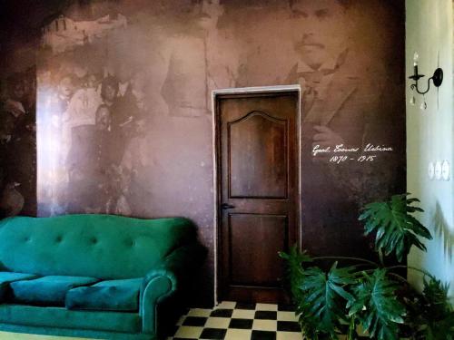 un divano verde in una stanza con parete di La Casa del General Hotel Boutique a Hidalgo del Parral