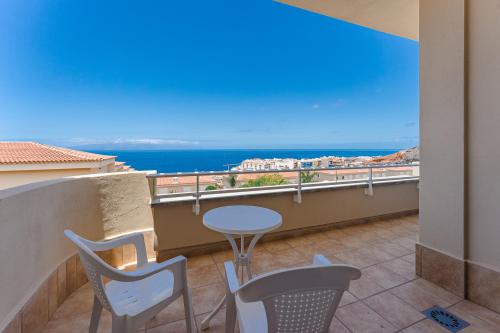 een balkon met een tafel en stoelen en de oceaan bij Santiago Astalavista sea view 4 in Puerto de Santiago