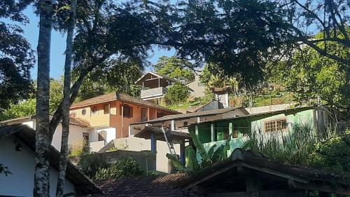 um grupo de casas numa colina com árvores em Pousada Mandala Sana em Sana