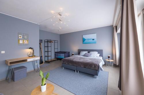 um quarto azul com uma cama e uma secretária em Family Appartement 'MarieO' with Game Room and outdoor facilities em Gistel