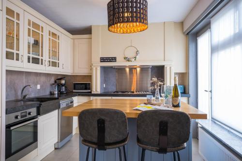 uma cozinha com uma mesa de madeira e 2 cadeiras em Family Appartement 'MarieO' with Game Room and outdoor facilities em Gistel