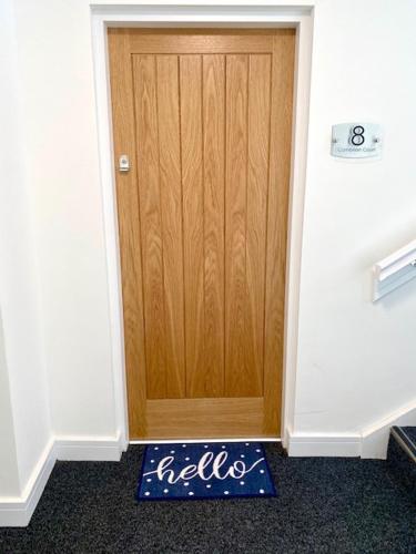 a door in a room with a welcome mat in front of it at Lovely New 2 Bedroom Condo with Stunning Seaviews in Penmaen-mawr