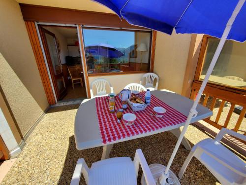 une table avec une assiette de nourriture et un parapluie dans l'établissement Font-Romeu vue imprenable Wifi gratuit, à Font-Romeu