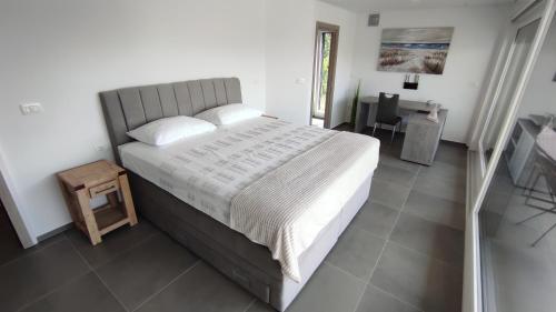 a bedroom with a large bed and a table at Villa Indigo in Umag