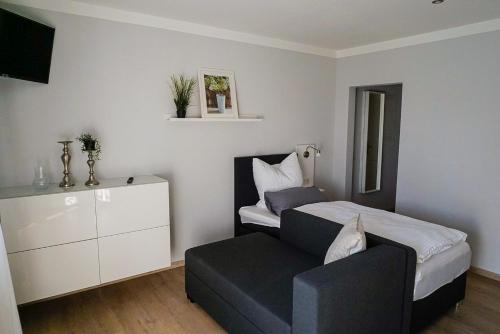 una camera da letto con un letto e una sedia di Zauberhaftes Stadthaus ad Altötting