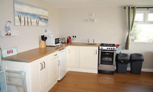 a kitchen with white cabinets and a stove top oven at Bubbles on the bay in Waterford