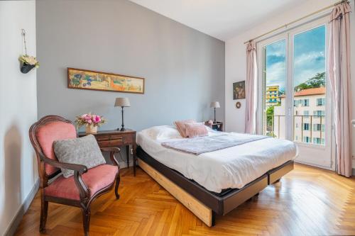 a bedroom with a bed and a desk and a chair at Le Maryland, Spacieux 2 pièces sur la Promenade des Anglais - Vue sur la mer in Nice
