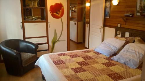- une chambre avec un lit, une chaise et une fleur dans l'établissement Meublé 4 pers saint Jean de luz, à Saint-Jean-de-Luz