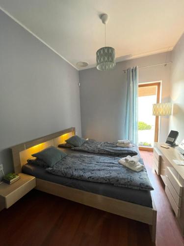 Un dormitorio con una cama grande y una ventana en Apartament przy lesie, en Chojno