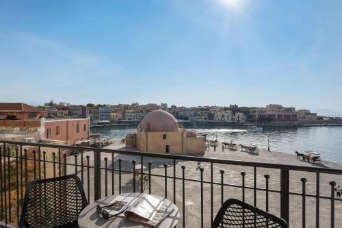 a balcony with a table and chairs and a body of water at La vista de Pablo in Chania Town
