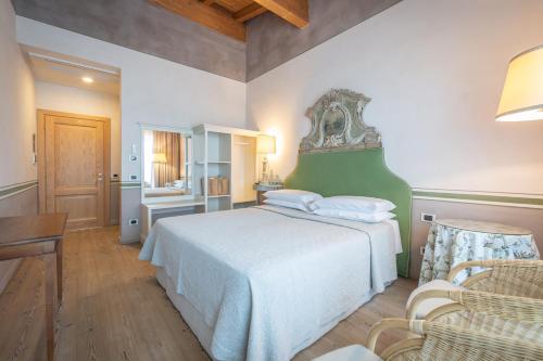 a bedroom with a large bed with a green headboard at Relais di Campagna I Tamasotti in Mezzane di Sotto