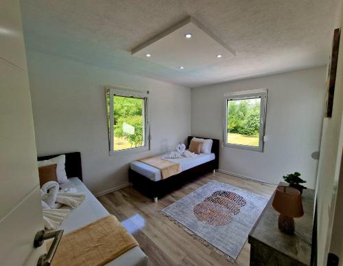 a small room with a bed and two windows at Villa Eda in Bihać