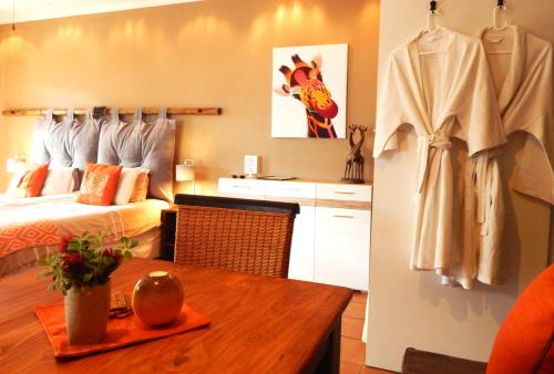 a hotel room with a bed and a table with a table at Khashamongo B & B in Somerset West