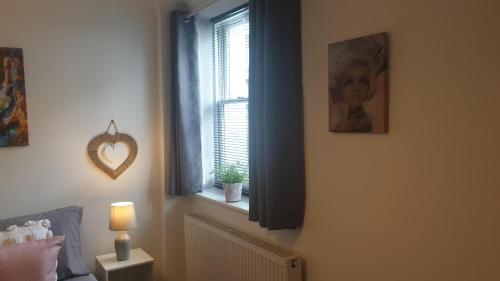 a bedroom with a window with a picture of a child at Beautiful Apartment 2 mins To The Beach in St. Leonards