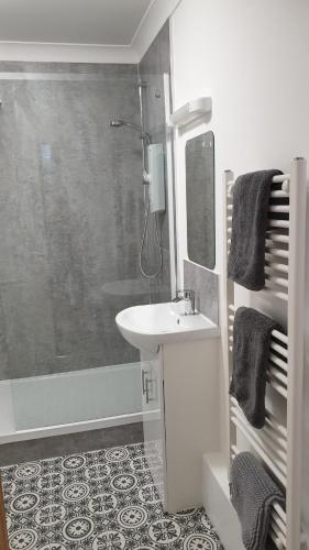 La salle de bains est pourvue d'une douche et d'un lavabo. dans l'établissement Beautiful Apartment 2 mins To The Beach, à St. Leonards