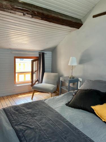 une chambre avec un lit, une chaise et une fenêtre dans l'établissement La marinière, à Honfleur