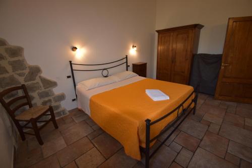a bedroom with a bed with an orange blanket at Falesta in Casole dʼElsa