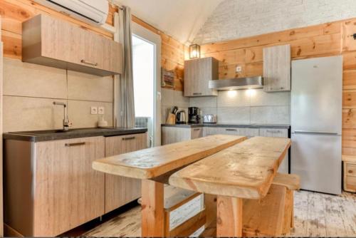 グリュイッサンにあるDuplex Climatisé 65m2 refait à neufのキッチン(木製テーブル、冷蔵庫付)