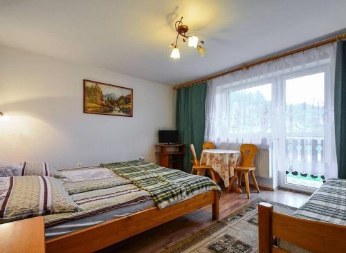 a bedroom with a bed and a table and a window at Pokoje gościnne u Bożenki in Krościenko