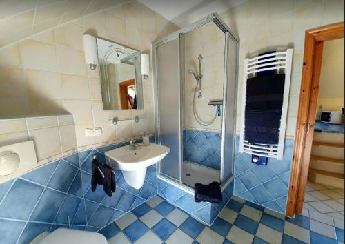 a blue and white bathroom with a sink and a shower at Ferienwohnung an der Havel in Priepert